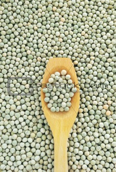 Wooden spoon and dried green split peas
