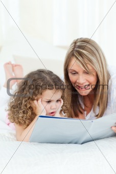 Young girl reading a book with her grandmother