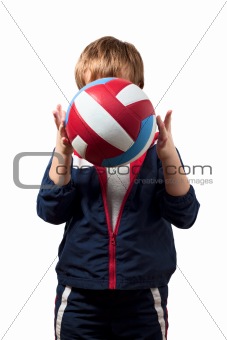 The cute little boy in a jumpsuit holds a ball
