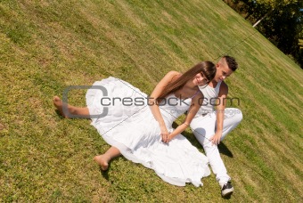 young couple happy sitting on grass white clothes, love relationship
