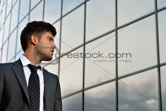 Young businessman looking good expectations on modern building background