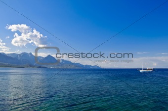 Sea, sky, mountains and small ship