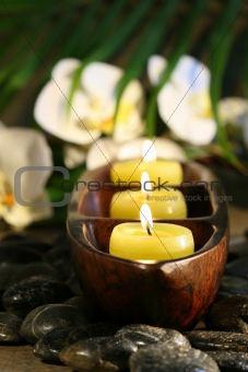 Spa setting with pebbles, candles and flowers