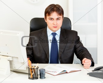 Dissatisfied modern businessman banging fist on table
