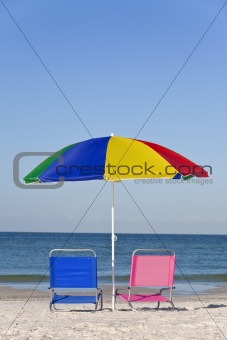 Colorful Beach Umbrella with Pink and Blue Deckchairs
