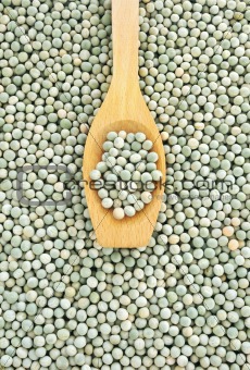 Wooden spoon and dried green split peas
