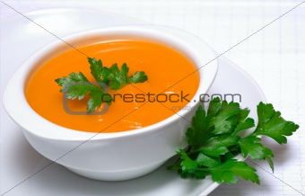 Pumpkin soup in white bowl  with parsley