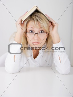 girl in glasses hidden under a book
