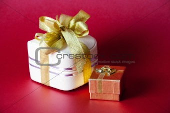 Two boxes with ribbon on a red background