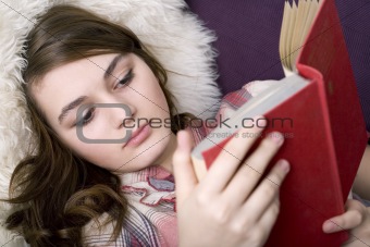 Beautiful girl reading book, closeup portrait