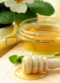 fresh golden honey in jar  with a wooden spoon