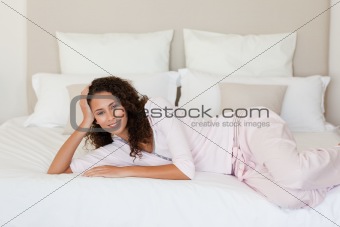 Beautiful woman lying down on her bed at home