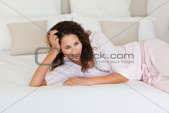 Beautiful woman lying down on her bed at home