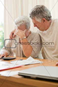 Sad mature couple calculating their domestic bills
