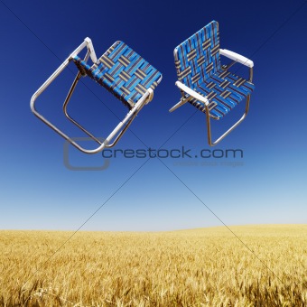 Lawn chairs over wheat field.