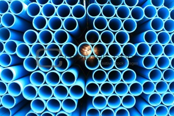 blue pipes stacked in construction site, pattern closeup