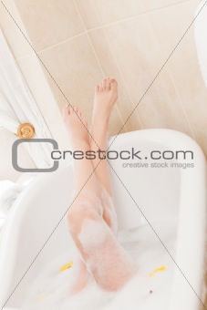Pretty woman taking a relaxing bath with a towel on her head 