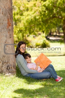 Mother with her daughter looking at their album photo