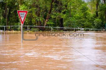 Very flooded road and give way sign