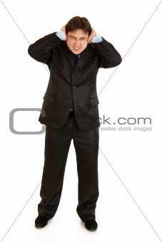 Annoyed businessman  closing ears with hands
