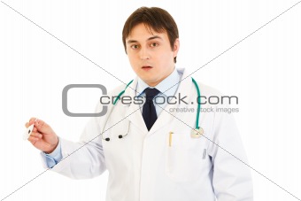 Shocked doctor holding  medical thermometer in hand
