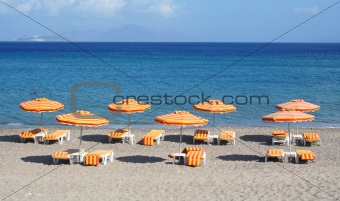 Greece. Kos island. Orange chairs and umbrellas on the beach