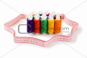 Spools Multi-colored threads standing group with a measuring tape of the tailor isolated on a white background