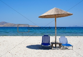 Greece. Kos island. Two chairs and umbrella on the beach