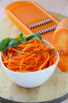 Carrot salad in white bowl  with basil
