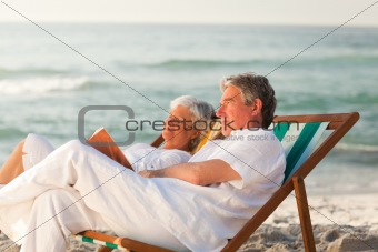 Man reading a book while his wife is sleeping