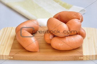 Delicious sausages on a cutting board 