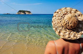 Young woman in hat looking at small island
