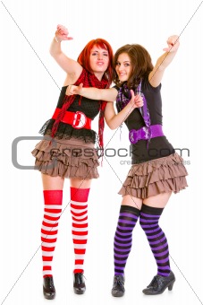 Two happy young girlfriends showing  thumbs up gesture

