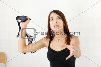 Angry woman with bra in hand.