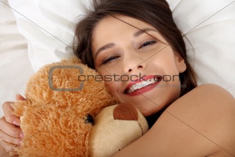 Girl in bed with teddy bear 