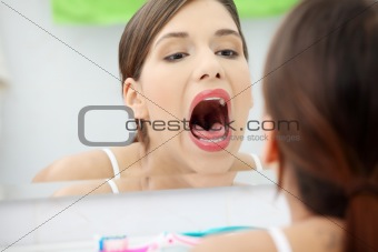 Young beautiful caucasian woman checking her throat