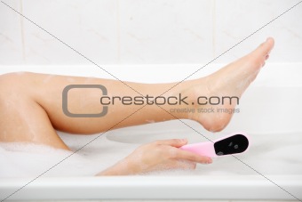 Woman in bath rubbing heel of foot