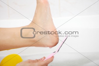 Woman in bath rubbing heel of foot