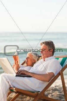 Woman reading while her husband is working on his laptop
