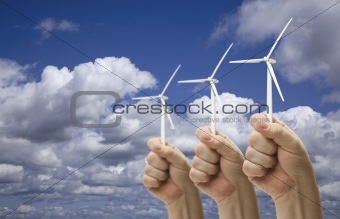 Male Fists Holding Three Wind Turbines Outside with Clouds and Sky.