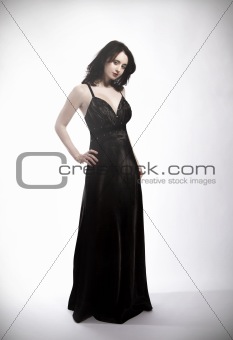 standing young beautiful woman in black dress