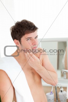 young man putting aftershave in the bathroom