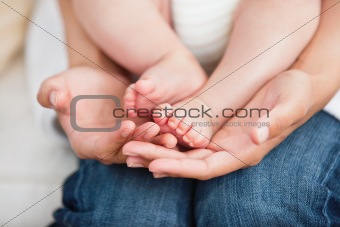 Close-up of a young mother sitting on the sofa with her baby