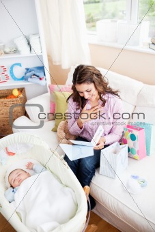 Bright woman sitting on the sofa with bags reading a card while 