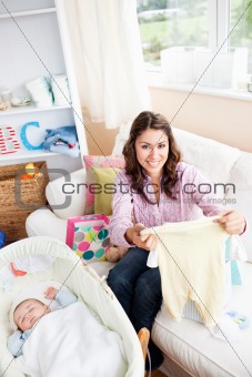 Joyful woman sitting on the sofa with bags reading a card while 