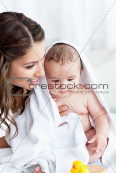 Delighted mother drying her baby after his bath