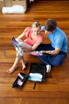 attractive couple sits on the floor picking colors