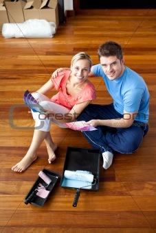 Beautiful couple sits on the floor picking colors