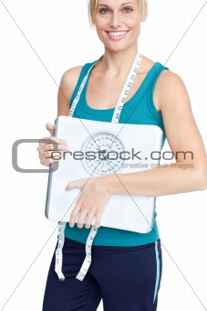 Smiling young woman holding a weight scale 