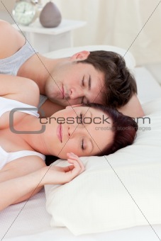 Young caucasian couple sleeping in bed
